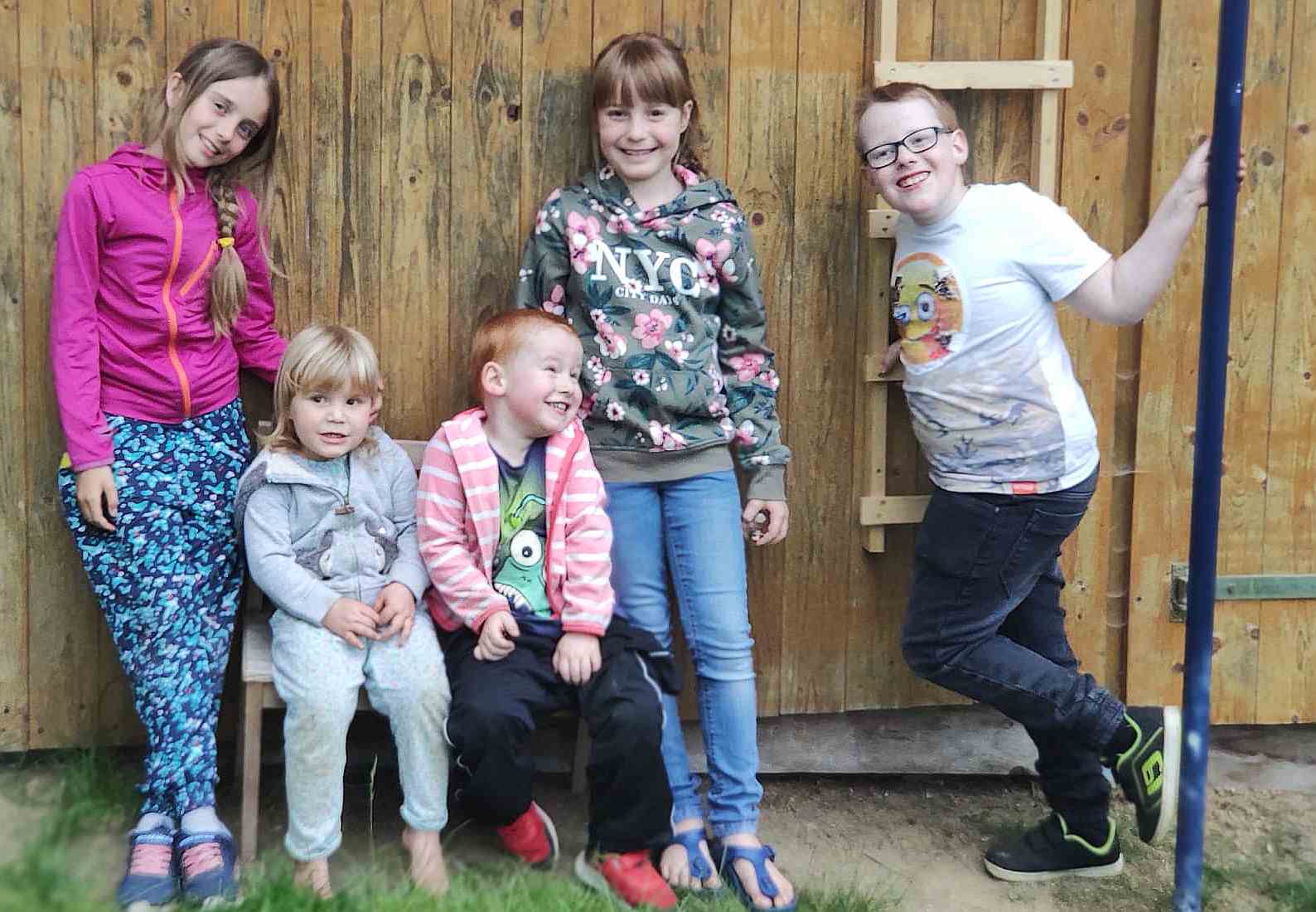 Kindern an vor Holzwand